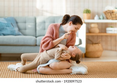 Mom And Her Daughter Child Girl Are Playing, Smiling And Hugging At Home. 