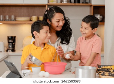 Mom with her Hispanic children preparing a cake at home - family time - happy single mother with her children - Latin lifestyle - Powered by Shutterstock