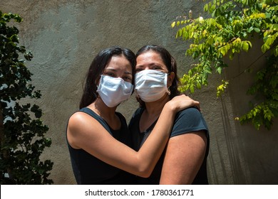 Mom With Her Masked Teenage Daughter Getting A Hug. Hispanic Wear Mask