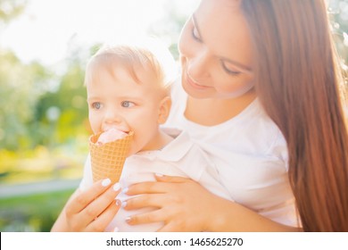 Mom With Her Son Kid Baby Eating Ice Cream In Park And Smiling, Laughing. Concept Happy Family.