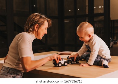 Mom And Her Toddler Son Plays With Car In Their Living Room.Soft Focus.