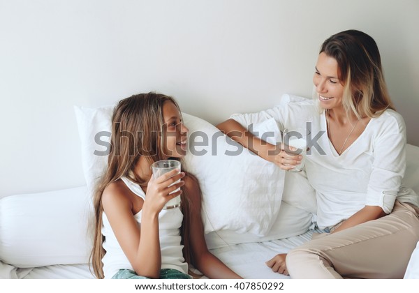 Mamá con su hija descansando en la cama sentimientos positivos buenas relaciones