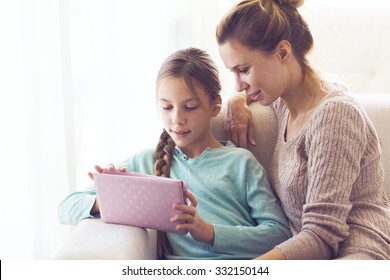 Mom with her tween daughter using ipad together