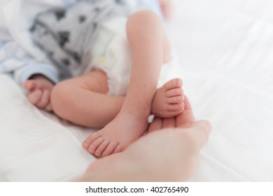 Mom Holding Baby Bare Feet In Her Hand 