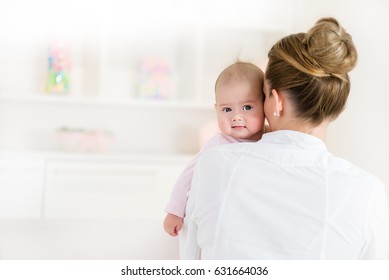 Mom Holding Little Baby Girl, Baby Looking At Camera.Copy Space