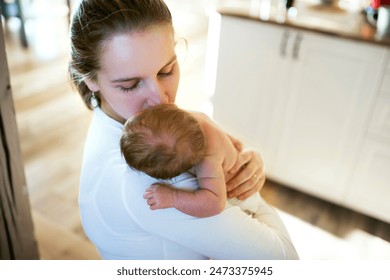 Mom holding newborn baby, looking at infant lovingly. Unconditional paternal love, Mother's Day concept. - Powered by Shutterstock