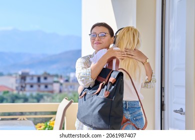 Mom Hugging Teenage Daughter On The Porch Of The House Near The Front Door, Meeting Goodbye.