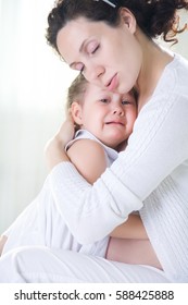 Mom Hugs A Crying Little Daughter At Home