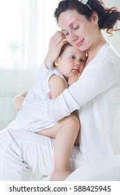 Mom Hugs A Crying Little Daughter At Home