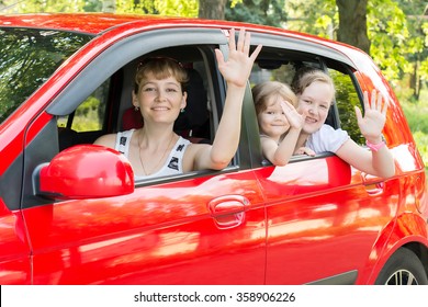 Mom With Kids Waving From The Window Of A Car