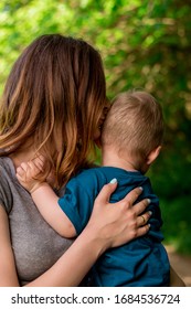 Mom Kisses A Small Child In The Head