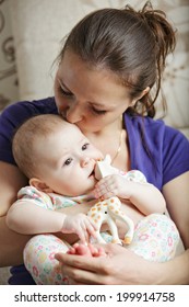 Mom Kissing Baby Head While Holding Her On Hands