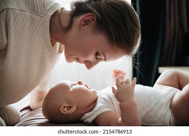 Mom lies with the baby on the bed, looking tenderly at the baby flat lay - Powered by Shutterstock