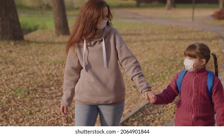 Mom Little Child With Backpack Walking Around Schoolyard Wearing Medical Masks, Mother Kid Rushing Merrily School Class For Lesson, Childhood Protected From Coronavirus Pandemic, Covid 19, First Grade