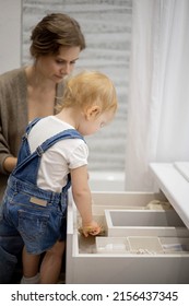 Mom And Little Daughter Organizing Bathroom Storage, Displaying Beauty Cosmetic Creams And Toiletries Into Drawer With Dividers. Bathroom Vanity Decluttering Concept By Using KonMari Method.