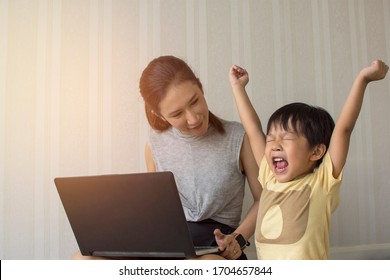 Mom And Little Son Cheering While Playing Game In Laptop,Happy Family Concept.