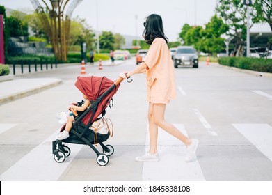 Mom and the little son on the stroller cross the road