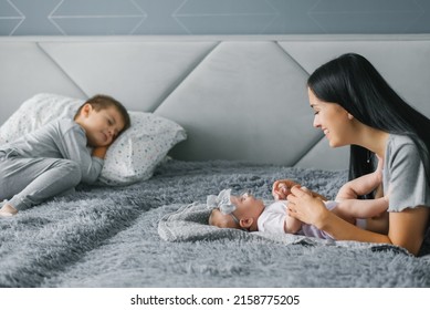 Mom Looks At Her Newborn Daughter, Who Lies On The Body. Family Happy With New Family Member