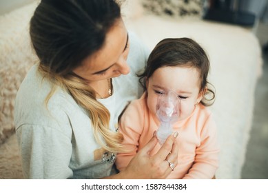 Mom makes inhalation of the child, holding hands cool - Shutterstock ID 1587844384