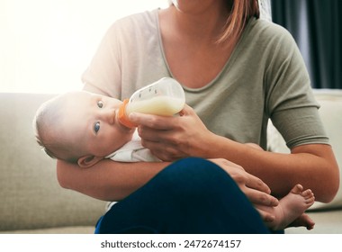 Mom, milk and feeding baby in living room for growth development, nutrition or digestive health. Lens flare, formula and woman with infant child for drinking, wellness or bonding with bottle in home - Powered by Shutterstock