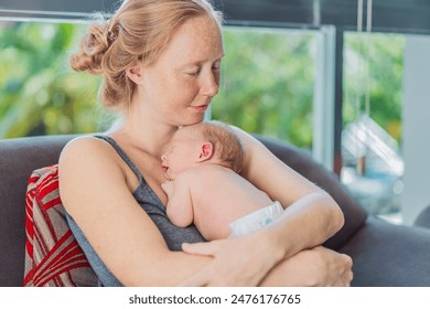 Mom with newborn baby relaxing on the sofa at home. This tender moment highlights the bond between mother and child in a comfortable and loving family environment - Powered by Shutterstock