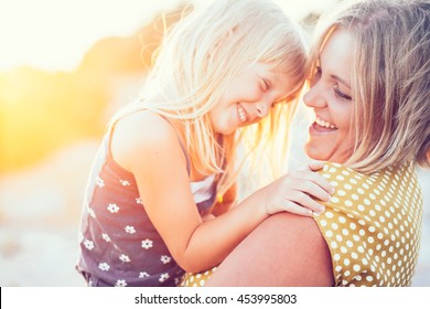 Mom Playing With Her Child Outdoors In Sunlight