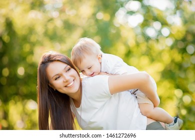 Mom plays with adorable baby son in park on grass. Sunlight summer. Concept Happy family. - Shutterstock ID 1461272696