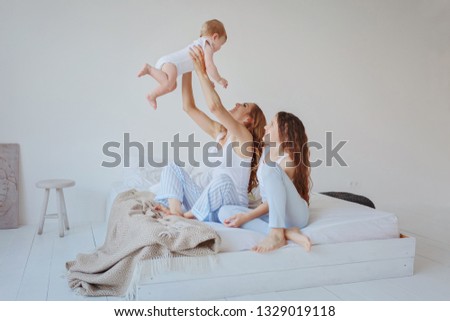 Similar – Relaxed mother and sons playing over the bed