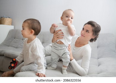 Mom Plays And Reads Books With Two  Little Kids. Mother Spends Time With Two Child Sons At Home.  Place For Text. Copy Space. Family Time At Home
