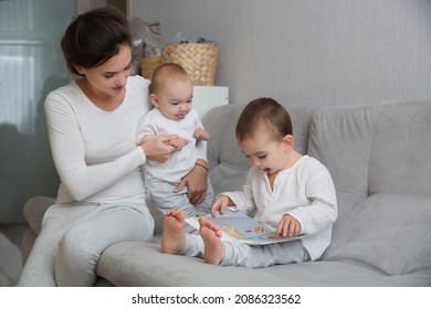 Mom Plays And Reads Books With Two  Little Kids. Mother Spends Time With Two Child Sons At Home.  Place For Text. Copy Space. Family Time At Home
