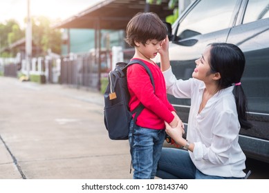 Mom Preparing To Send Her Children Back To School At Car In Morning. Education And Back To School Concept. Happy Family And Loving Of People Theme.