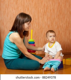 Mom Puts The Baby On The Potty At Home