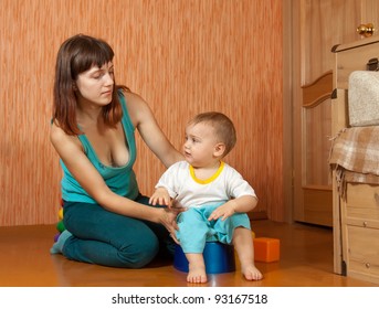 Mom Puts The Baby On The Potty At Home