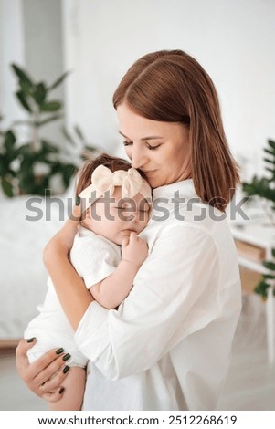 mom puts the baby to sleep by rocking him, mom holds the baby in her arms gently hugging and kissing him, mother and child, healthy sleep of the child with the mother.
