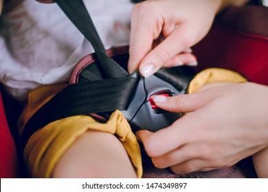 Mom Puts Her Little Son In A Car Seat And Buckles Him