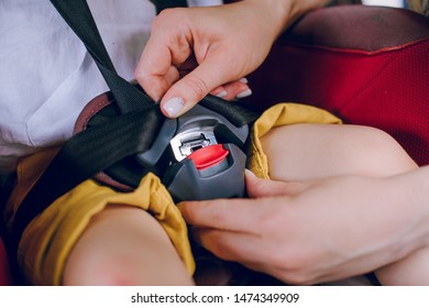 Mom Puts Her Little Son In A Car Seat And Buckles Him