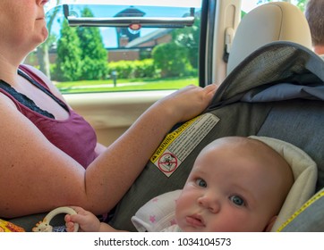 Mom Rides In Backseat With Baby In Carseat Whie Dad Drives The Suv