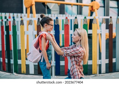 Mom Saying Goodbye To Her Daughter Before Going To School. Back To School And Education Concept. 