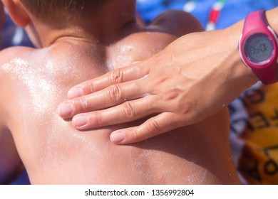 Mom Smears Her Baby Skin Sun Cream On Beach. Sunscreen