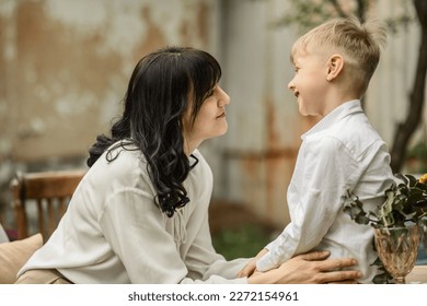 Mom and son 5-6 years old in the courtyard of a country house are resting in the spring. the concept of motherhood and love for children, simple country life in the village, mom's day - Powered by Shutterstock