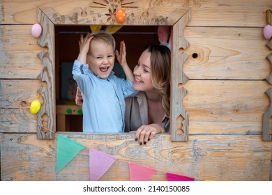 mom and son in bunny ears celebrate easter, play in the playhouse. Happy easter.