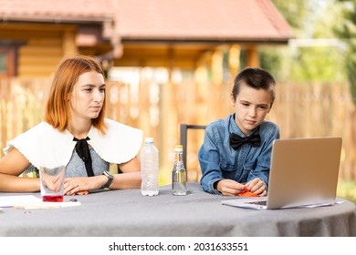 Mom And Son Are Conducting Chemical Experiments At Home. An Experience With A Child About Creating A Rocket Launcher Using A Bottle, Soda And Vinegar.