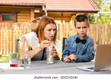 Mom And Son Are Conducting Chemical Experiments At Home. An Experience With A Child About Creating A Rocket Launcher Using A Bottle, Soda And Vinegar.