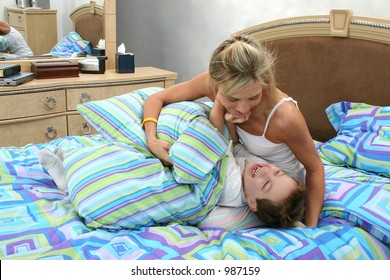 Mom And Son Having Tickle Fight At Home In Bed.