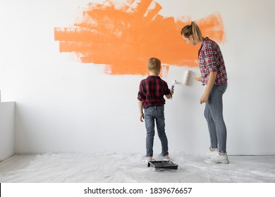mom   son are painting the wall and orange paint  home renovation concept