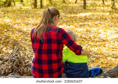 Mom And Son Are Resting In The Autumn Forest. Forest Walk. Mom Hugs Her Son.