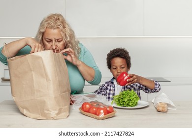 Mom And Son Taking Out Groceries From The Paper Shopping Bag. Food Delivery