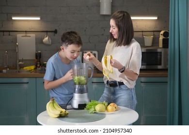 mom and son teenager makes a smoothie in the kitchen in the morning. healthy nutrition in the family, vegetarianism - Powered by Shutterstock