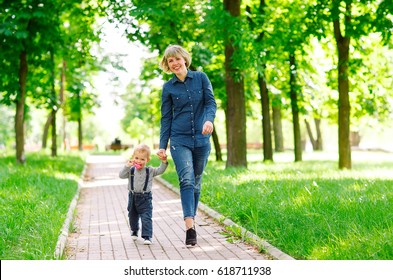 Mom And Son Walking In The Park.