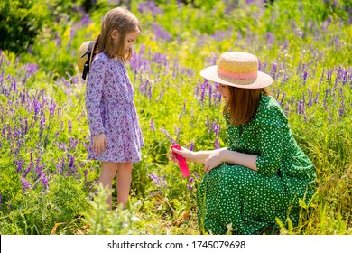 The Mom Spray Treatment The Daughter The Means From Mosquitoes And Ticks For A Walk In The Summer Field. Family Walks On The Nature.